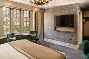 um quarto de hotel com uma cama e uma televisão de ecrã plano em Brig o' Doon House Hotel em Ayr