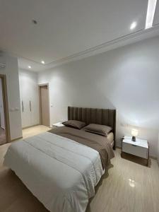 sypialnia z dużym łóżkiem i dwoma stołami w obiekcie Moderne S2 Jardin de Carthage w mieście Tunis