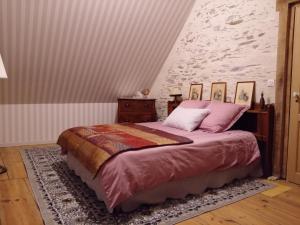 - une chambre avec un lit et des oreillers roses dans l'établissement à la Mainguère, chambres d'hôtes, 