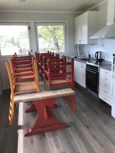 a kitchen with red chairs and a table in a kitchen at Volsdalen Camping in Ålesund