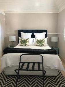 a bedroom with a black and white bed and two lamps at The Bakers Cottage in Armidale