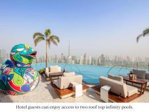 a resort with a pool with chairs and a statue at SLS Dubai Hotel & Residences in Dubai
