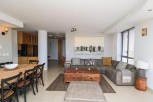 a living room with a couch and a table at 1402 Hibernian Towers Luxury Self Catering Apartment Strand Western Cape South Africa in Cape Town