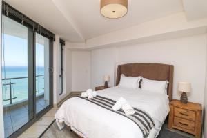 a bedroom with a bed with a view of the ocean at 1402 Hibernian Towers Luxury Self Catering Apartment Strand Western Cape South Africa in Cape Town +22 photos