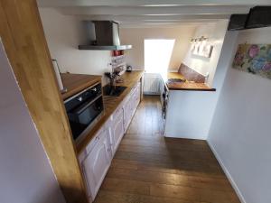 a kitchen with white cabinets and a wooden floor at Phare des Impressionnistes in Honfleur