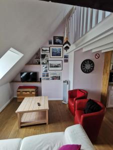 uma sala de estar com um sofá vermelho e uma mesa em Phare des Impressionnistes em Honfleur