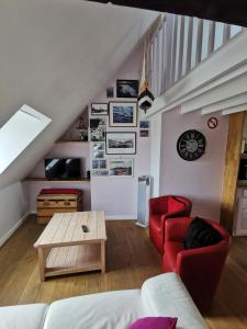 - un salon avec un canapé rouge et une table dans l'établissement Phare des Impressionnistes, à Honfleur