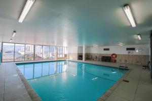 a large swimming pool with blue water in a building at 1402 Hibernian Towers Luxury Self Catering Apartment Strand Western Cape South Africa in Cape Town