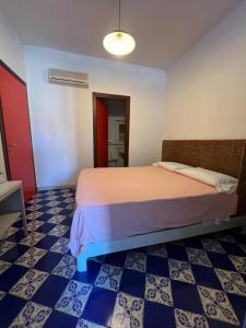 Sant'Andrea في كابو دورلاندو: غرفة نوم بسرير وأرضية زرقاء وبيضاء