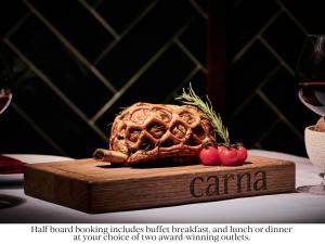 a steak on a cutting board on a table with wine glasses at SLS Dubai Hotel & Residences in Dubai