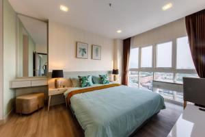 1 dormitorio con cama, escritorio y ventana en Prio signature condo, en Chiang Mai