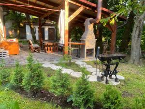 een tuin met een grill en een houten paviljoen bij Hotel Окремий Будинок-Апартаменти in Rakoshyno