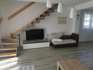 a living room with a tv and a staircase at Žuta kuća in Grude