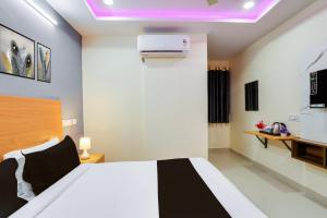 a bedroom with a white bed and a projector on the ceiling at Super Townhouse Gachibowli Near Sky View in Kondapur
