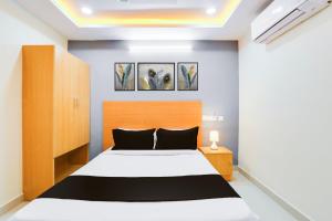 a bedroom with a white bed and two paintings on the wall at Super Townhouse Gachibowli Near Sky View in Kondapur