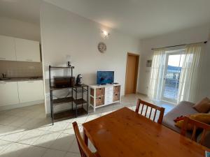 uma sala de estar com uma mesa de madeira e uma cozinha em Seaview apartments em Poljica