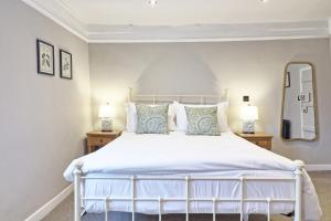 a bedroom with a large white bed with two lamps at Ranfield's Brasserie Hotel Rooms in Coggeshall