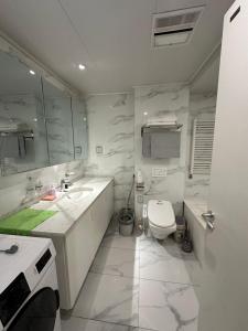La salle de bains blanche est pourvue de toilettes et d'un lavabo. dans l'établissement Classic apartment at Circus, à Oulan-Bator