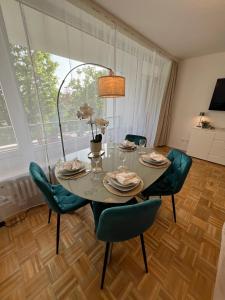 een eetkamer met een tafel en groene stoelen bij W&D living - FeWo Kleines Italien mit Parkplatz und Balkon in Celle