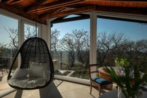 um alpendre com uma cadeira, uma mesa e uma janela em La Locanda Del Pontefice - Luxury Country House em Castel Gandolfo
