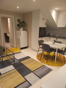 a kitchen with a table and chairs and a table and a table and a kitchen at Hanaborg apartment in Lorenskog