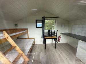 Habitación con litera, mesa y silla. en Volsdalen Camping, en Ålesund