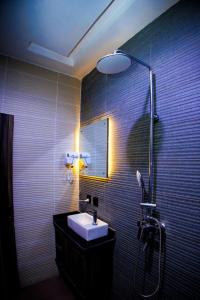 a bathroom with a sink and a shower at Vic & J Lounge and Hotel Asaba in Asaba