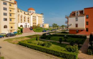 a building with a garden in front of a street at ADIRAMA Apartments Elegant Apartments Walk to the Beach in Obzor