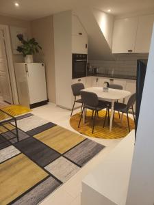 a kitchen with a table and chairs and a refrigerator at Hanaborg apartment in Lorenskog
