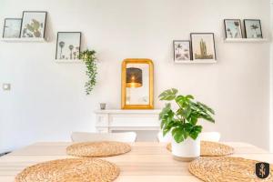 einen Esstisch mit einem Spiegel und einer Pflanze in der Unterkunft La Casa Relaxio — Un nid douillet en hyper centre in Caen