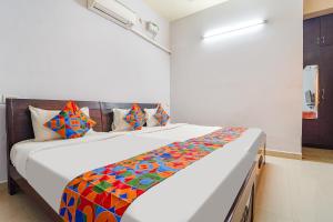 - une chambre avec un grand lit et une couverture colorée dans l'établissement FabExpress Its South East Residency, à Chennai