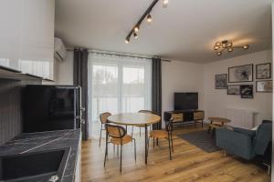 a living room with a table and chairs and a tv at Apartamenty przy Dworku in Człuchów