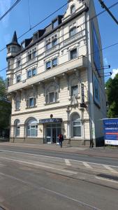 杜伊斯堡的住宿－Rheinischer Hof，街道拐角处的白色大建筑