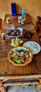 a wooden table with plates of food on it at Edsan Apartment in Bantayan Island