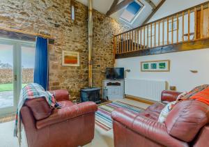 sala de estar con 2 sillas de cuero y fogones en Haytongate Cottage, en Carlisle