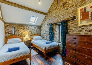 2 camas en una habitación con una pared de ladrillo en Haytongate Cottage, en Carlisle