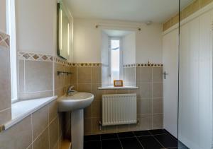 y baño con lavabo, aseo y espejo. en Haytongate Cottage, en Carlisle
