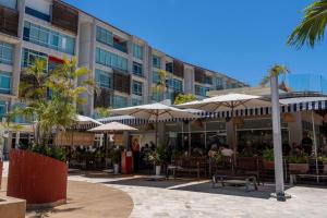 a restaurant with tables and umbrellas in front of a building at Nayarit Coastal Retreat New Luxury Haven in Nuevo Vallarta 