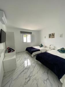 a bedroom with two beds and a television in it at Villa Cecilia, Maspalomas (Nuevo a estrenar) in Maspalomas