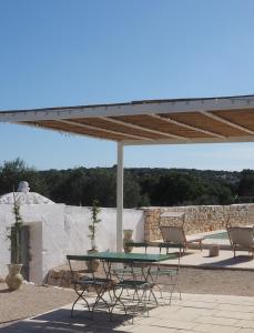 a patio with a table and chairs under a pavilion at Antica Masseria San Benedetto in Ostuni