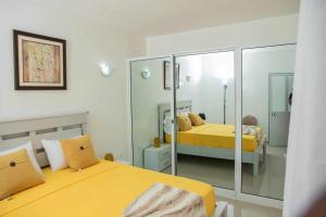 una camera con due letti e uno specchio di Zeyden Place Apt 2 a Praia