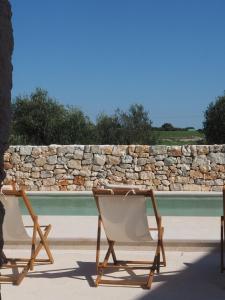 two folding chairs sitting next to a pool at Antica Masseria San Benedetto in Ostuni