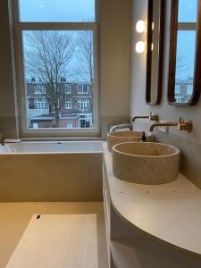 La salle de bains est pourvue de 2 lavabos et d'une fenêtre. dans l'établissement Luxery family home, Haarlem, close to beach and Amsterdam, à Haarlem