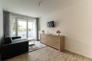 een woonkamer met een bank en een tv bij Moulin à Vent Nord - Appt à 20 minutes de Paris in Bondy