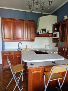 eine Küche mit einer Spüle und einer Theke mit Stühlen in der Unterkunft Blue sea in Pula