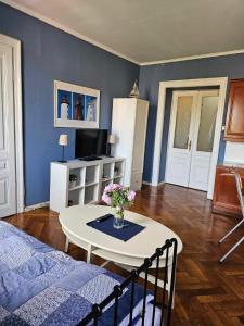 ein Wohnzimmer mit einem Bett und einem Tisch mit Blumen in der Unterkunft Blue sea in Pula