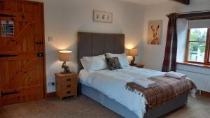 a bedroom with a bed and two lamps and a window at Treliver Farm in Saint Wenn