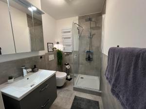een badkamer met wastafel, douche en toilet bij W&D living - FeWo Kleines Italien mit Parkplatz und Balkon in Celle +39 foto's
