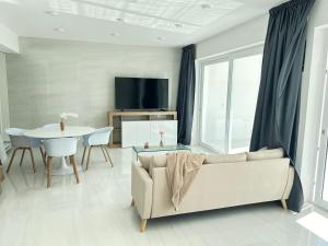 Smart Luxury Suites & Apartments في أروسييْ: غرفة معيشة مع أريكة وطاولة