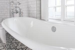 uma banheira branca na casa de banho com uma janela em Keszthely Balaton Luxury Villa em Keszthely